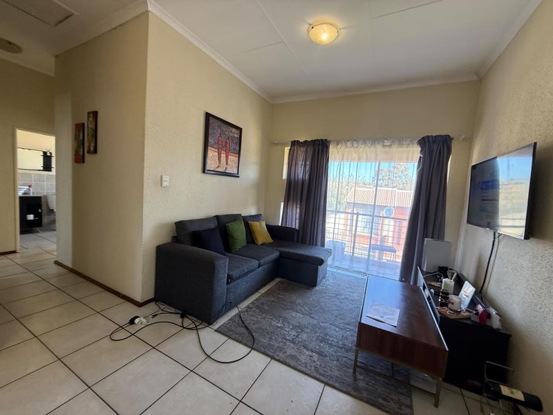 A living room featuring tiled flooring and a sliding glass door providing access to an outdoor area.