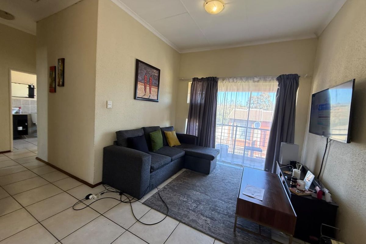 A living room featuring tiled flooring and a sliding glass door providing access to an outdoor area.
