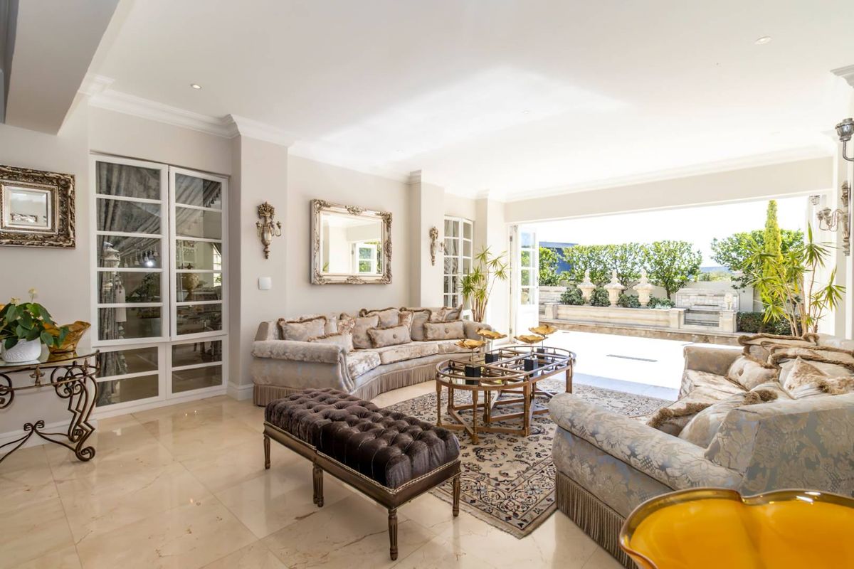 Spacious living room featuring polished stone flooring, recessed lighting, and large glass doors opening onto a private patio area.