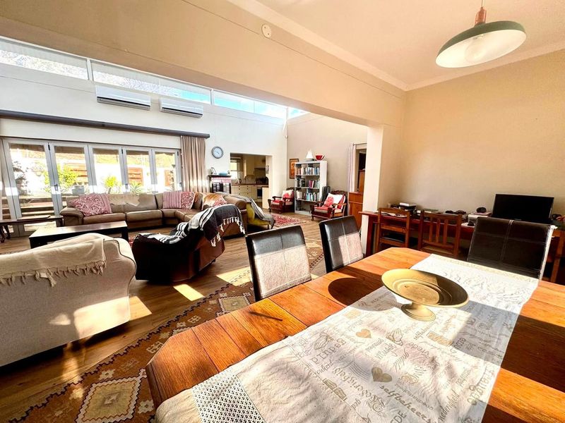 Spacious open-plan living and dining area featuring high ceilings, clerestory windows, and bi-fold doors that provide seamless access to the outdoor space.