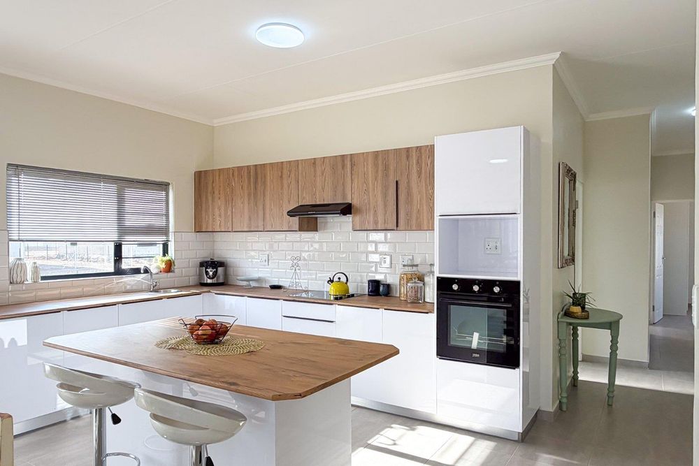 Large kitchen with white gloss cupboards and kitchen island.