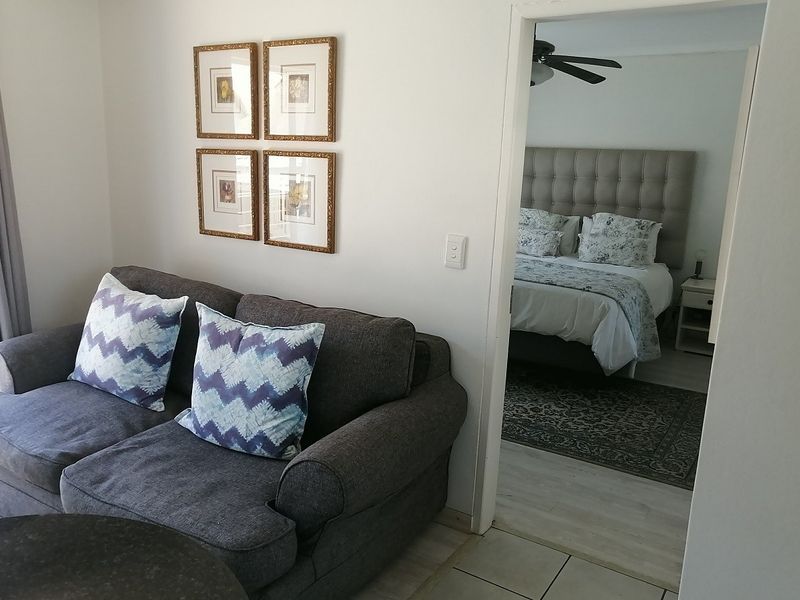 A view from the living area looking into an adjacent bedroom, featuring neutral wall finishes and tiled flooring.