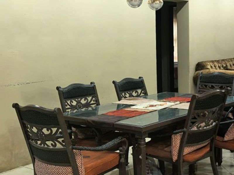 A dining area featuring tiled flooring, coved ceilings, and a modern decorative pendant light fixture.