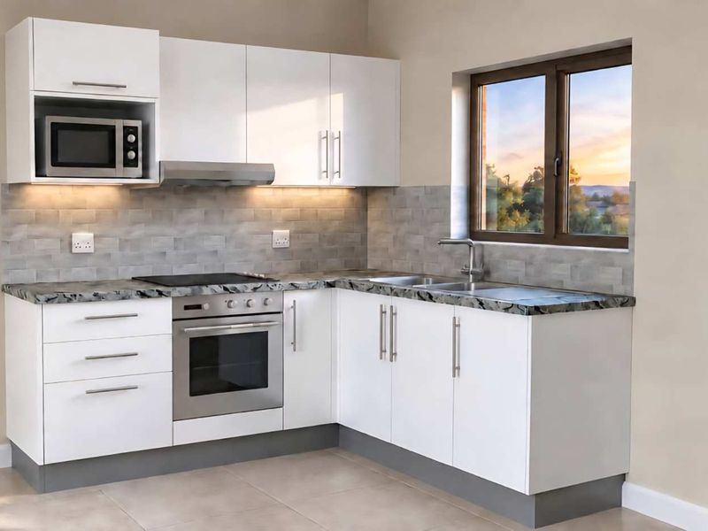 Modern kitchen featuring white cabinetry, stone-look countertops, built-in oven, hob, extractor fan, and a tiled backsplash with a window view.