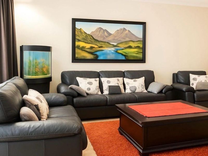 A comfortable living room space featuring neutral wall tones and tiled flooring, providing a functional area for relaxation.