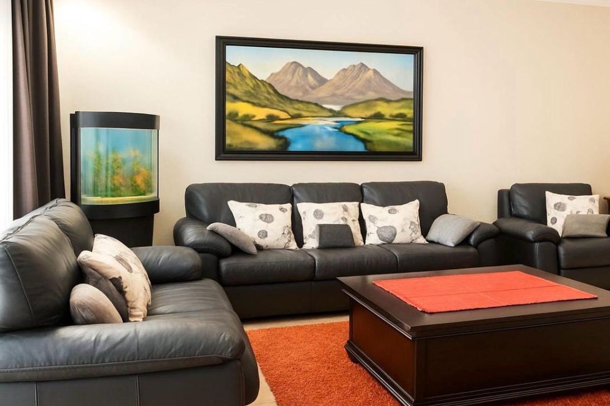 A comfortable living room space featuring neutral wall tones and tiled flooring, providing a functional area for relaxation.