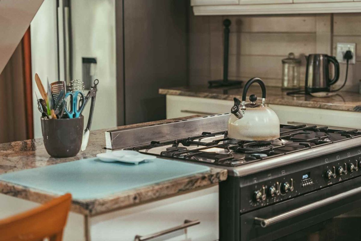 A close-up view of a kitchen island featuring a granite countertop and a built-in gas stove with an oven.