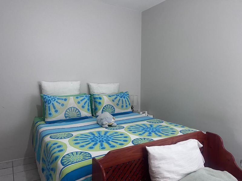 A standard bedroom featuring neutral wall paint and tiled flooring, providing a functional and simple living space.