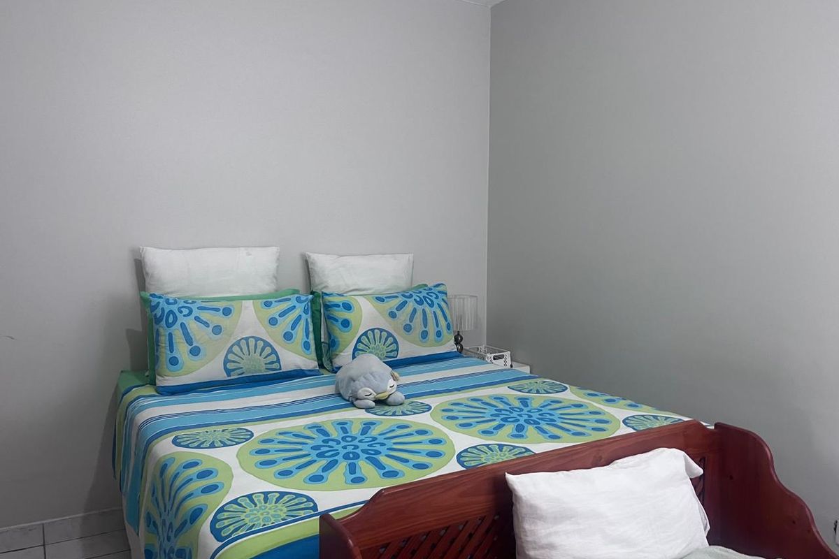 A standard bedroom featuring neutral wall paint and tiled flooring, providing a functional and simple living space.