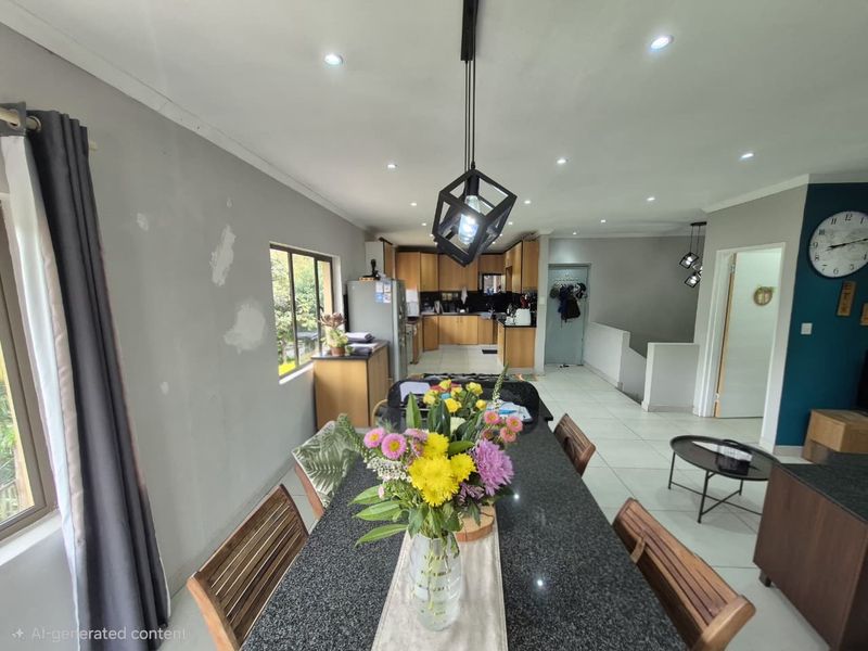 Open-plan kitchen and dining area featuring granite countertops, wooden cabinetry, and recessed lighting, with some wall surface repairs required.