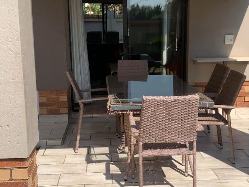 A covered patio area featuring tiled flooring and a sliding glass door providing access to the interior living space.