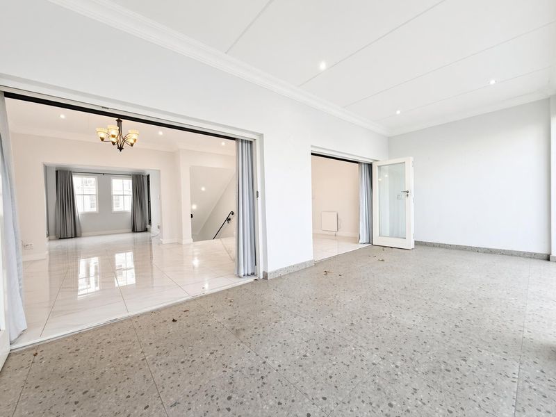 Spacious covered patio featuring terrazzo-style flooring and large glass doors providing seamless access to the interior living areas.