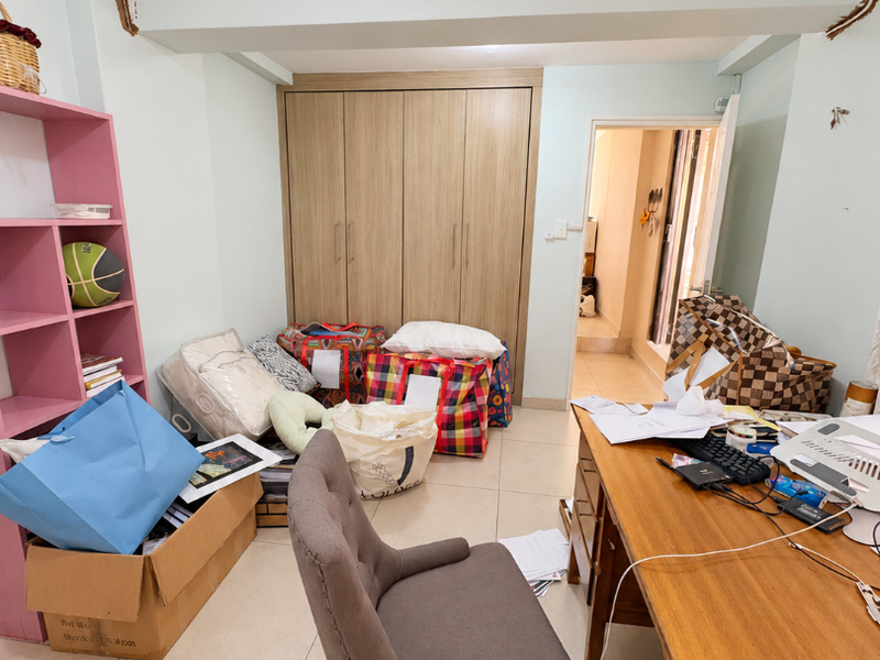 A bedroom featuring built-in wooden wardrobes and tiled flooring, currently requiring ceiling repairs and finishing work to improve the overall aesthetic.