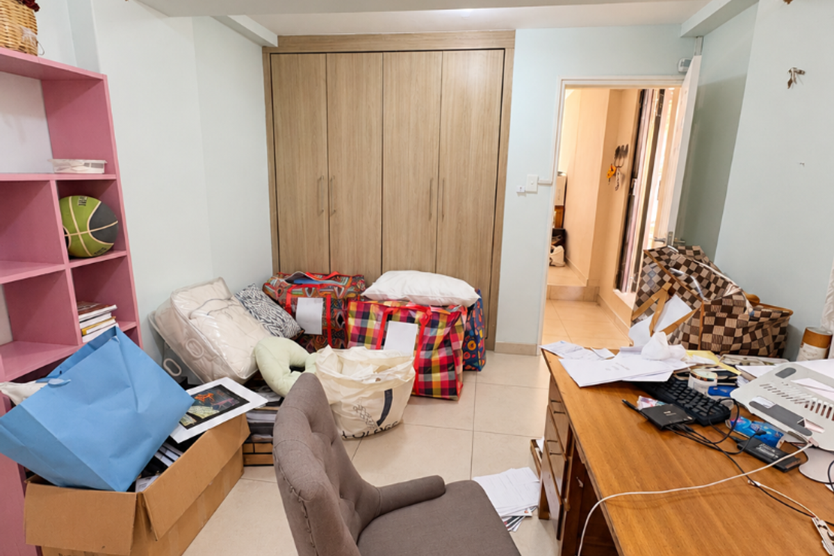 A bedroom featuring built-in wooden wardrobes and tiled flooring, currently requiring ceiling repairs and finishing work to improve the overall aesthetic.