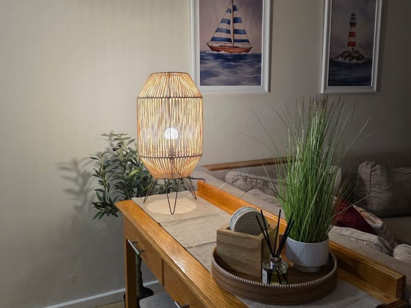 A cozy living room area featuring light-toned laminate flooring and decorative coving, creating a warm and inviting atmosphere.