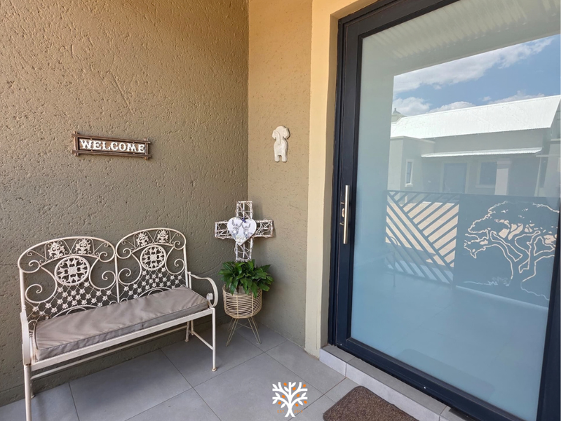 A welcoming entrance area featuring a modern frosted glass door and clean tiled flooring, providing a bright and inviting transition into the home.