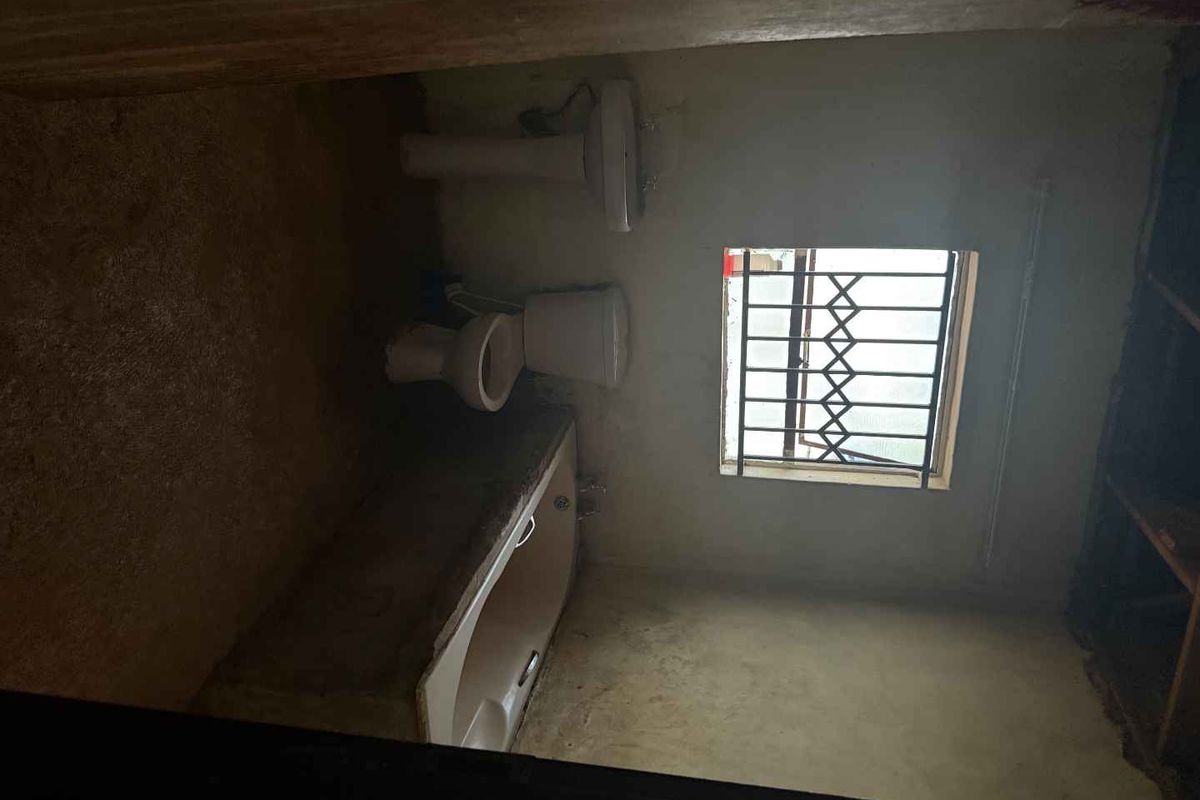 A dated bathroom featuring a built-in bathtub, pedestal basin, and toilet, requiring significant renovation and cosmetic updates to improve functionality and aesthetic appeal.