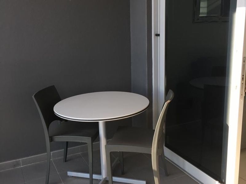 A compact balcony featuring tiled flooring and a large sliding glass door providing access to the interior living space.