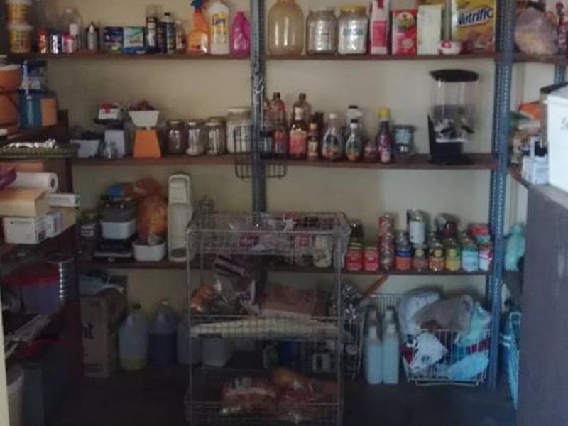 A functional utility or pantry space featuring extensive open industrial-style shelving for storage and organization.