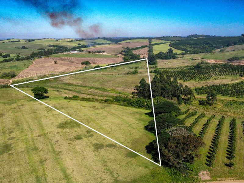 An aerial view of a large agricultural farm property featuring expansive open fields and established orchard rows.