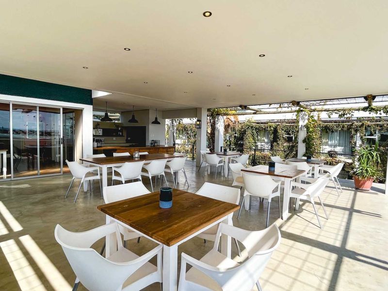 A spacious covered outdoor patio featuring concrete flooring, recessed lighting, and direct access to the interior through large sliding glass doors.