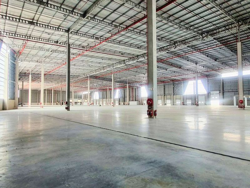 Expansive industrial warehouse space featuring high ceilings, polished concrete flooring, integrated fire suppression systems, and a robust steel portal frame structure.