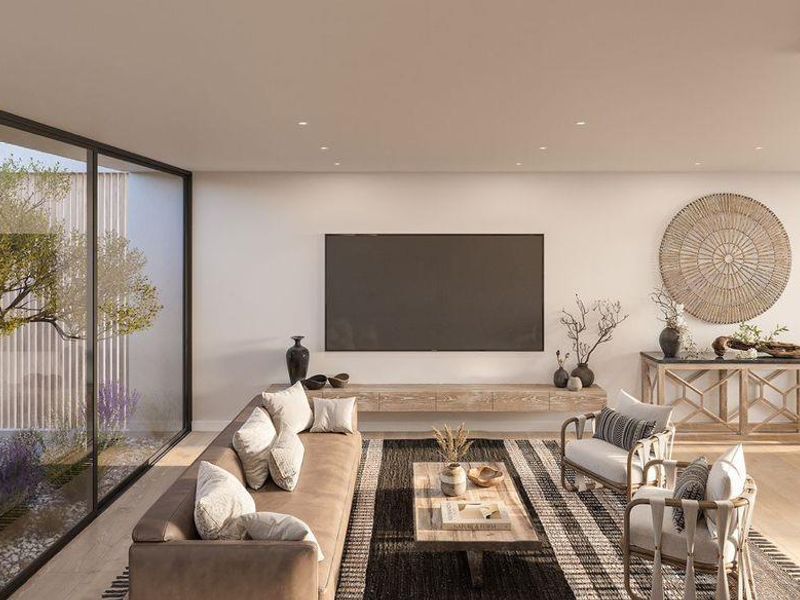 Spacious open-plan living area featuring large sliding glass doors, modern recessed lighting, a floating media console, and a contemporary staircase.