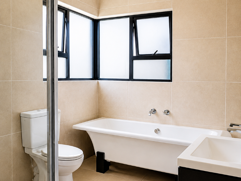 A modern, well-maintained bathroom featuring a freestanding bathtub, a separate shower enclosure, a vanity basin, and neutral floor-to-ceiling wall tiles.