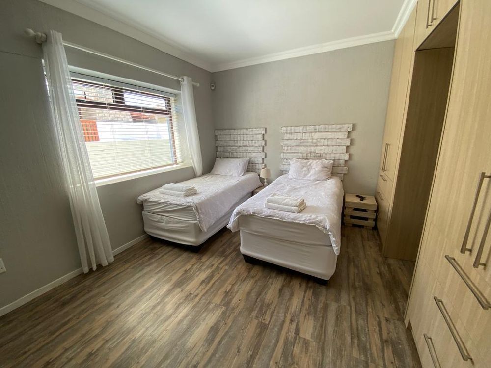 Ground floor, bedroom 3 with built-in cupboards, TV and en-suite bathroom. 