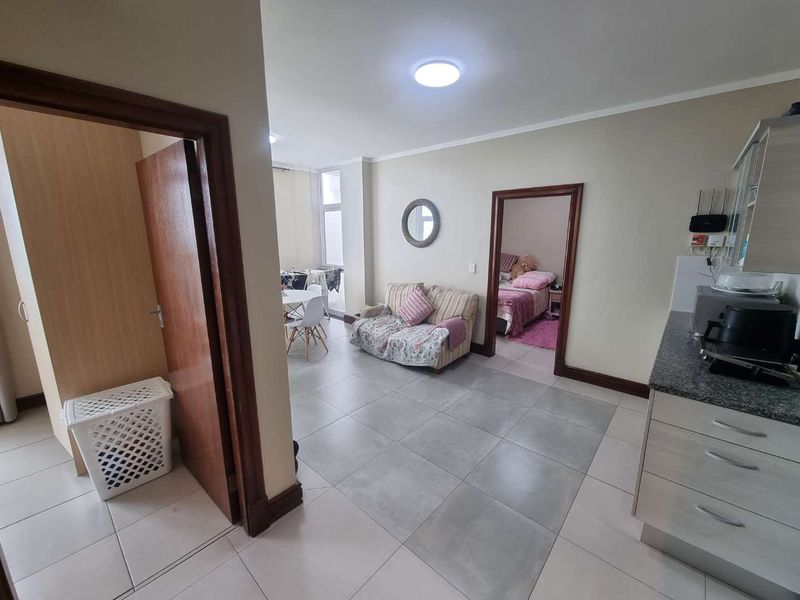 Open plan living area featuring tiled flooring, integrated kitchen cabinetry with granite countertops, and direct access to adjacent rooms.
