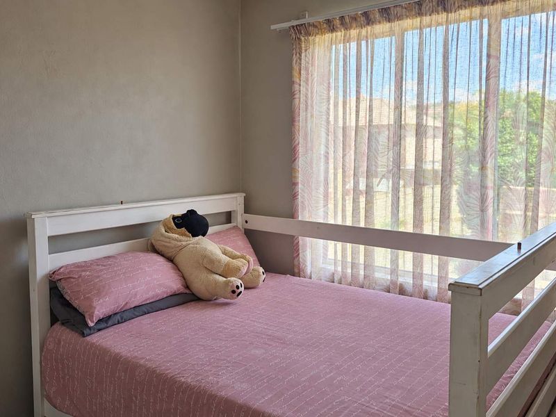 A bedroom featuring a window with a curtain rail, providing natural light and a view of the exterior.