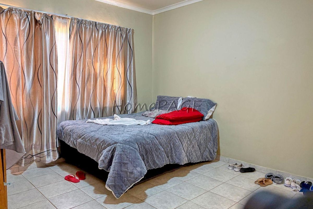 A standard bedroom featuring tiled flooring and curtain rails, providing a functional space ready for personalization.