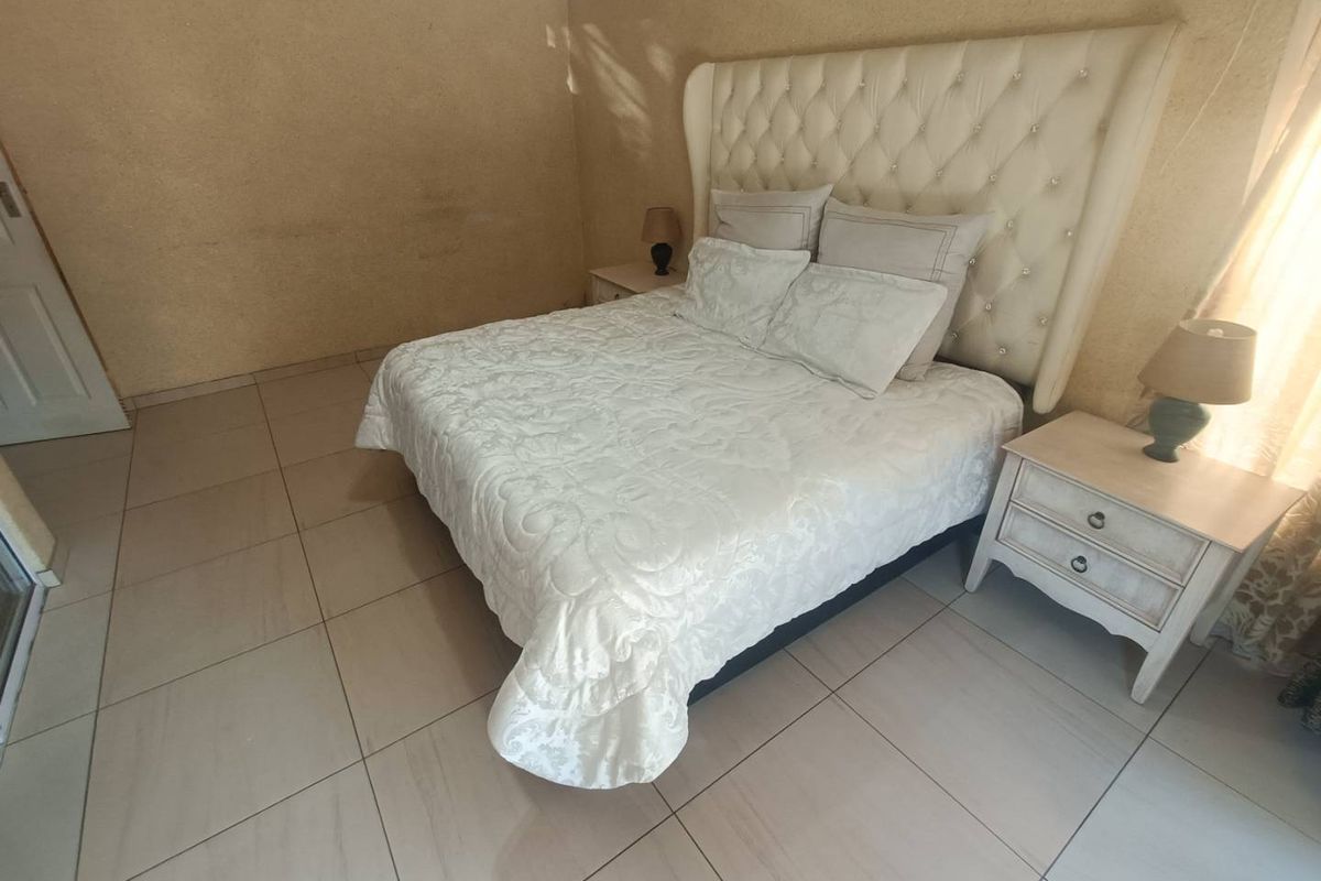 A bedroom featuring tiled flooring and textured wall finishes, providing a neutral base for potential interior updates.