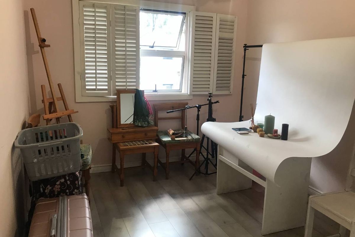 A bedroom featuring light-toned wood-look flooring and white plantation shutters on the window, providing a neutral base for various uses.