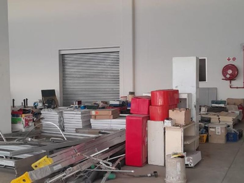 Spacious industrial utility area featuring high ceilings, concrete flooring, a roller shutter door, and integrated fire safety equipment.