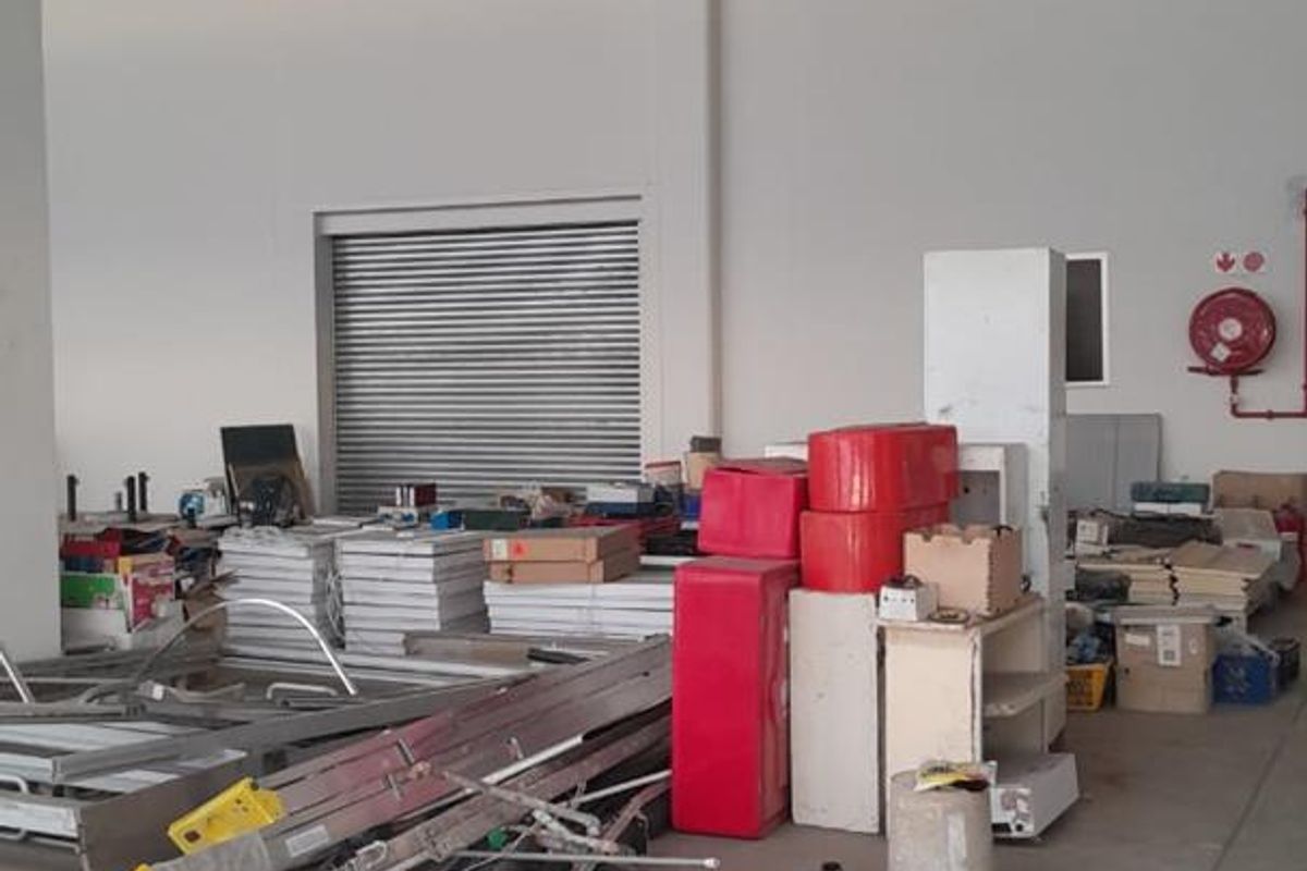 Spacious industrial utility area featuring high ceilings, concrete flooring, a roller shutter door, and integrated fire safety equipment.