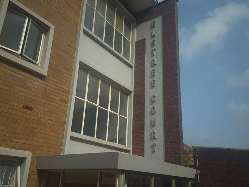 Exterior view of the Elstree Court apartment building, featuring a brick facade, entrance canopy, and multi-pane windows.