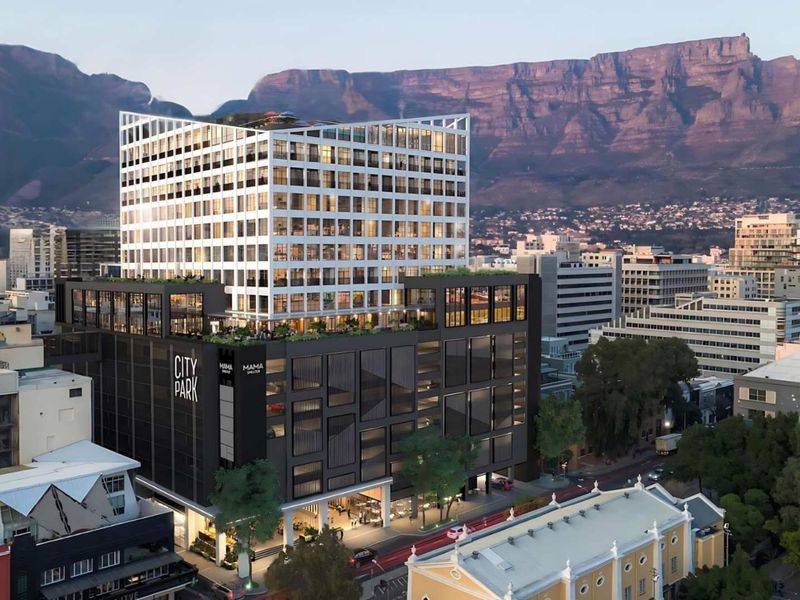 Aerial view of the City Park commercial building featuring a modern multi-story design with a rooftop terrace and mountain backdrop.