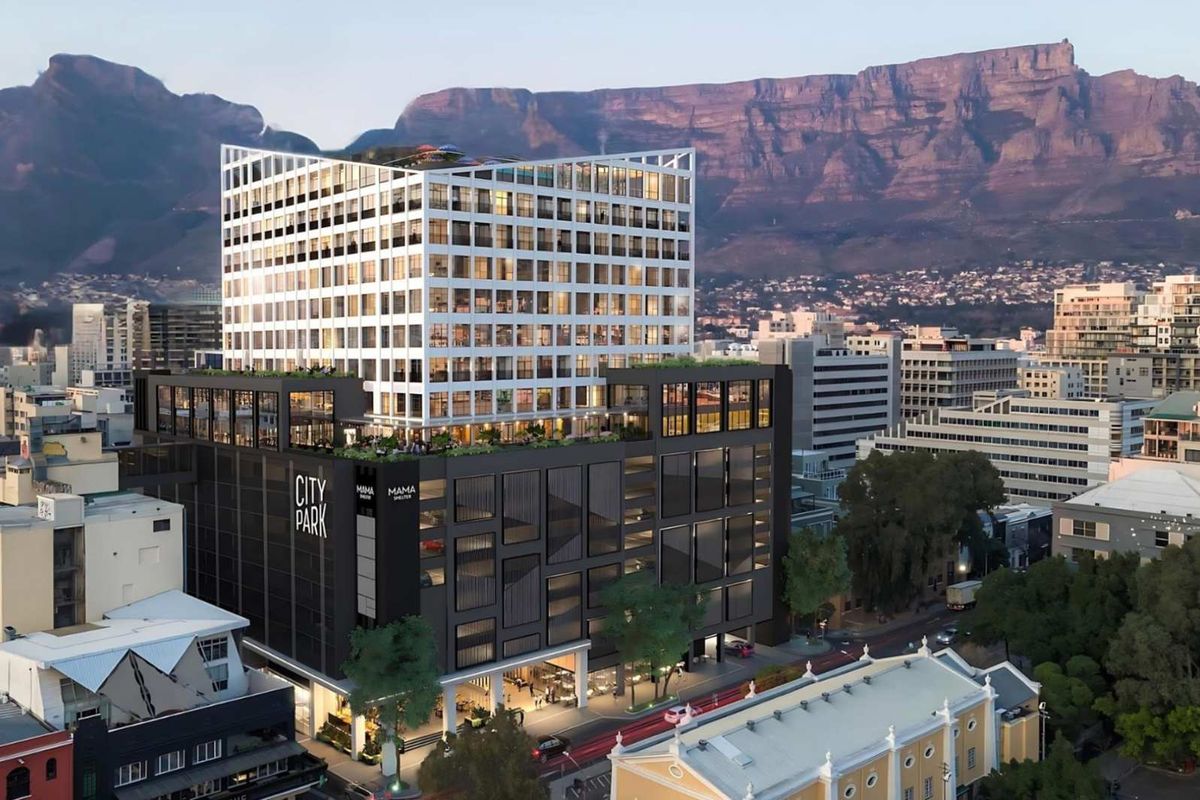 Aerial view of the City Park commercial building featuring a modern multi-story design with a rooftop terrace and mountain backdrop.