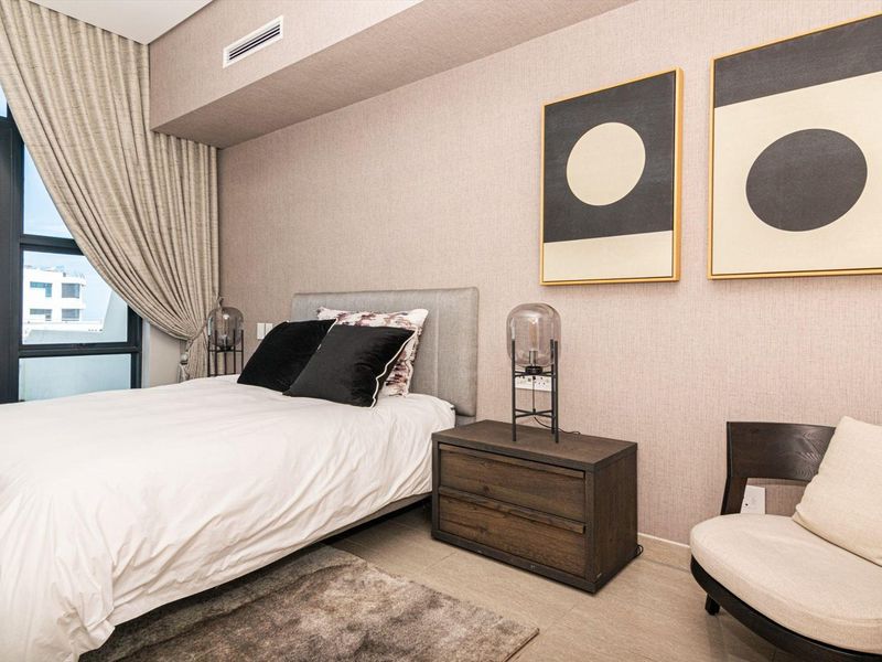 A well-maintained bedroom featuring textured wallpaper, tiled flooring, and integrated ducted air conditioning with a large window providing natural light.