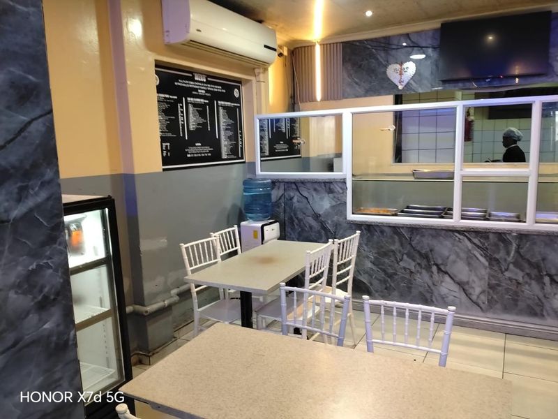 Interior view of a retail food service area featuring a service counter, tiled flooring, and wall-mounted menu board.