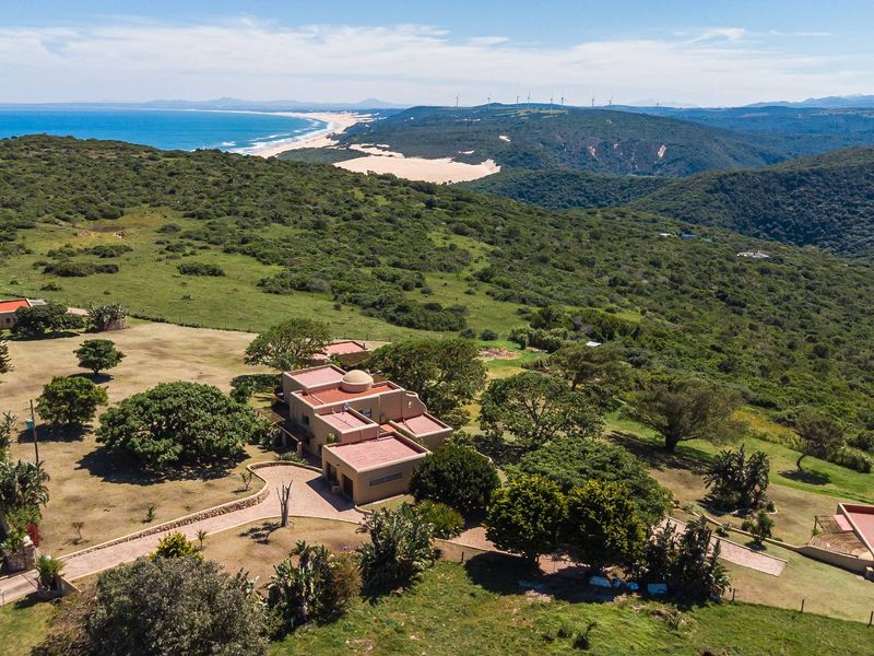 Aerial view of a small holding property featuring multiple structures with terracotta roofs, extensive grounds, and panoramic coastal and landscape views.