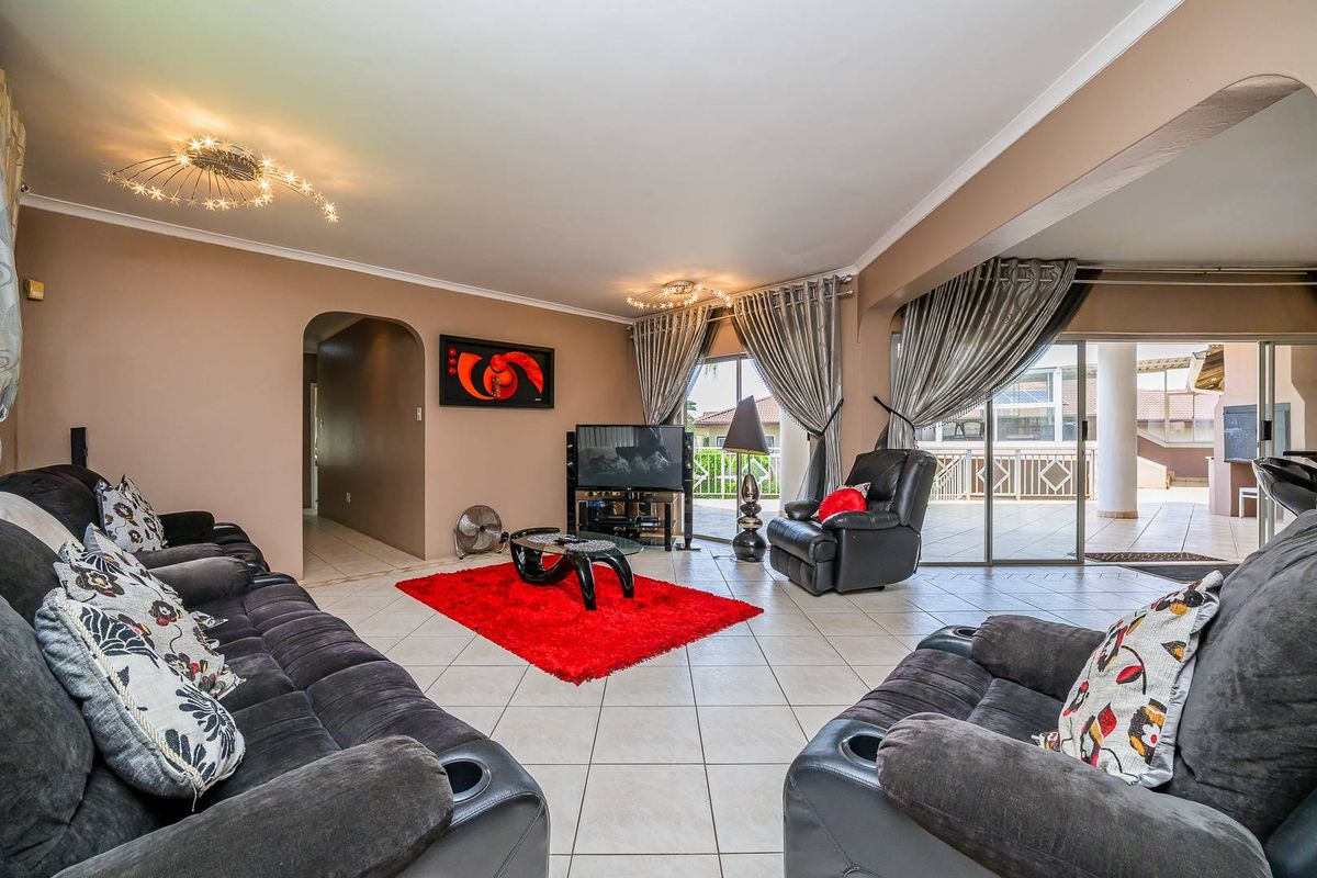 Spacious living room featuring tiled flooring, recessed lighting, and large sliding glass doors providing seamless access to the covered outdoor patio area.
