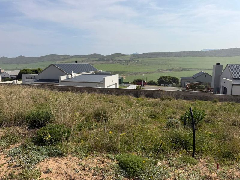 A view from the vacant residential plot overlooking the surrounding landscape and neighbouring properties.