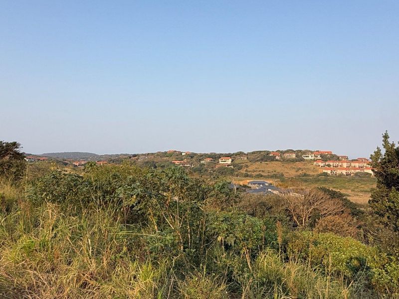 A scenic view overlooking a natural landscape with surrounding residential developments in the distance.