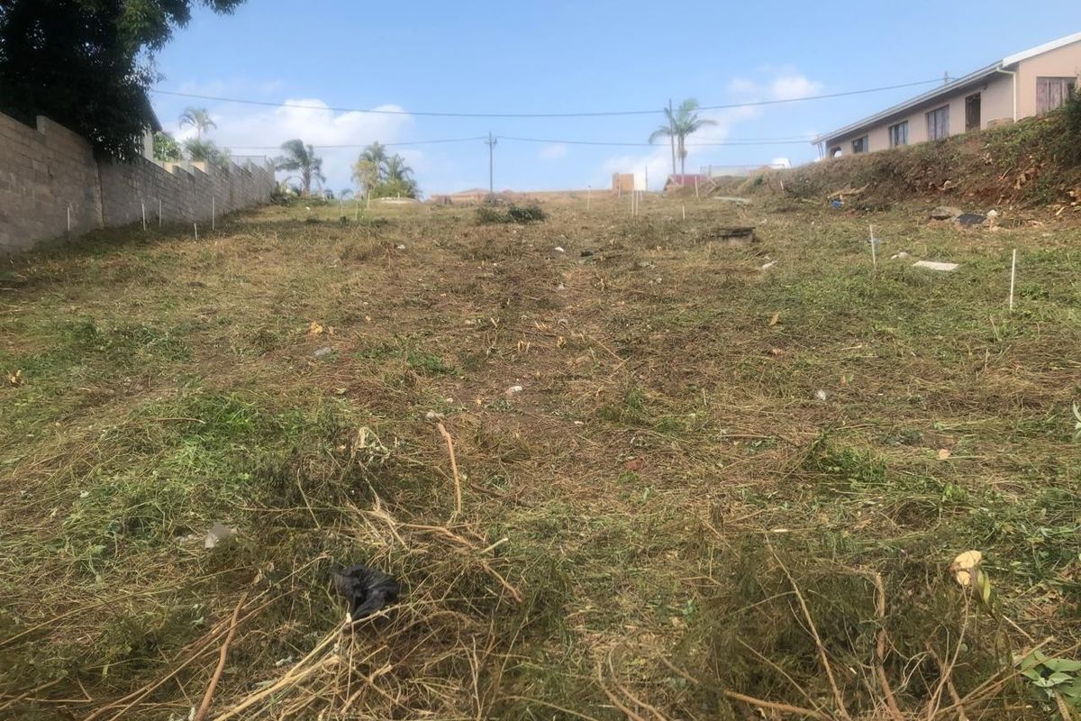 A vacant residential plot of land featuring a cleared surface and boundary wall, ready for development.