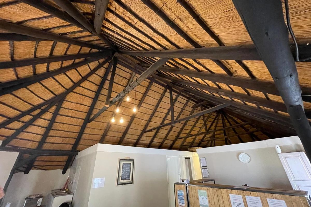 Interior view of a spacious room featuring a high vaulted thatched ceiling with exposed timber beams and a built-in reception counter.