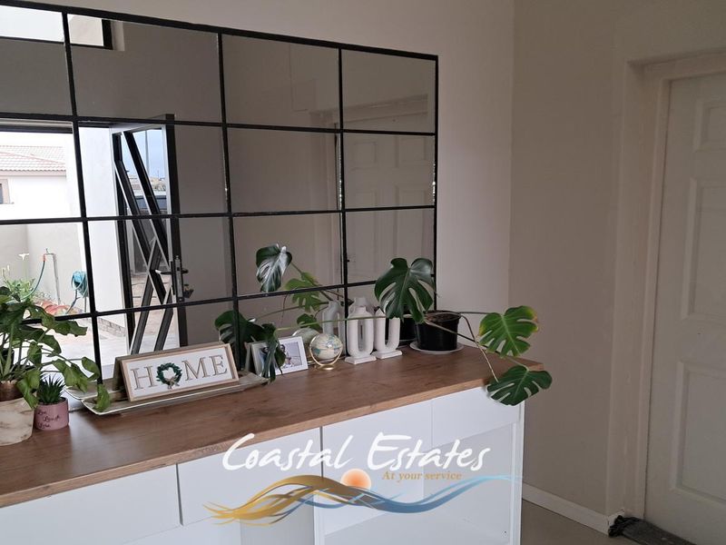 A bright living area featuring a modern grid-style wall mirror and built-in cabinetry, providing a clean and contemporary aesthetic.