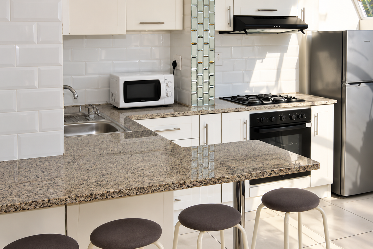 A well-maintained kitchen featuring granite countertops, subway tile backsplash, built-in oven with gas hob, and integrated cabinetry.