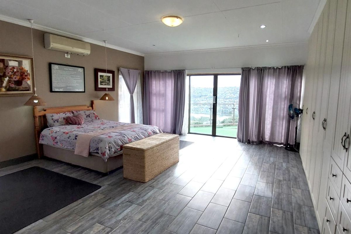 Spacious bedroom featuring built-in cupboards, tiled flooring, air conditioning, and a sliding glass door providing access to an outdoor balcony area.